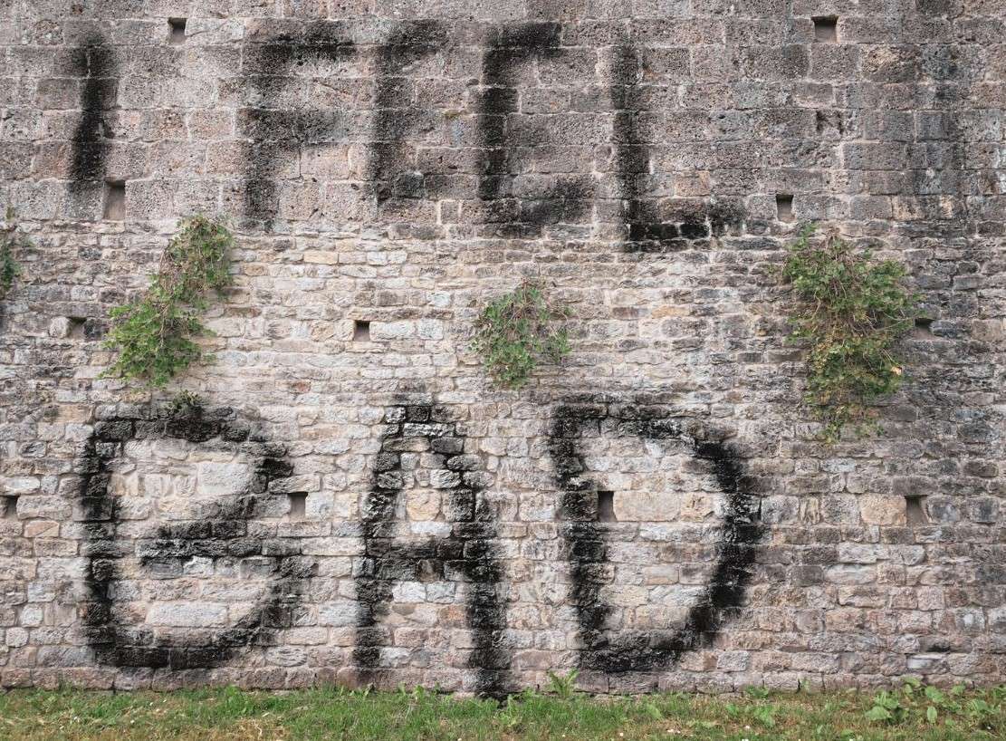 Brick wall painted with graffiti that says "I feel Bad"